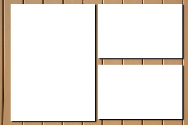 Три пустых белых пустых кадра в макете на фоне деревянной стены