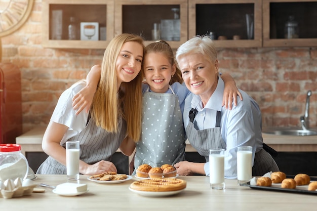 Three family generations having breakfast together, mom, daughter and granny eating cakes and drinking milk at kitchen, copy space