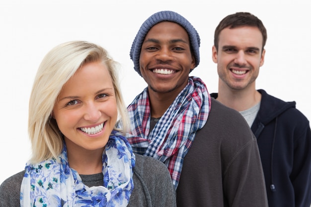 Three fashionable friends looking at camera and smiling