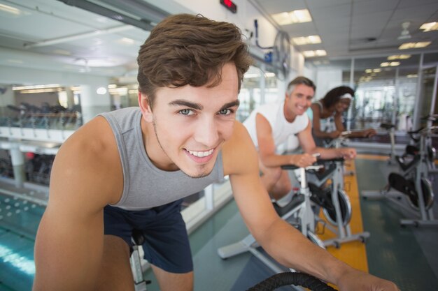 Three fit people working out on exercise bikes