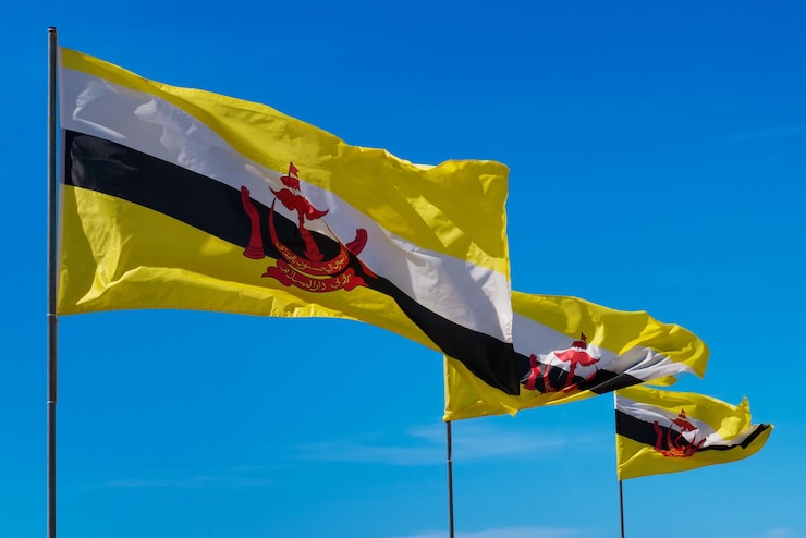 Photo three flags poles of brunei darussalam on sky background