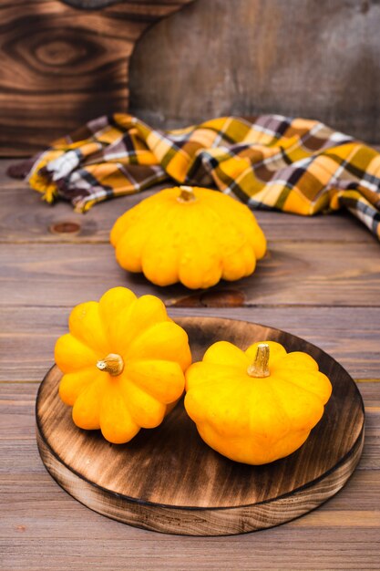 Three fresh squash on a cutting board on wooden background 