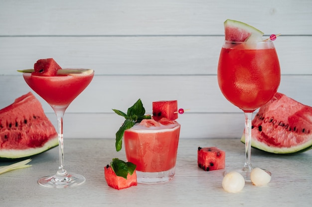 Three fresh watermelon cocktails on a wooden table