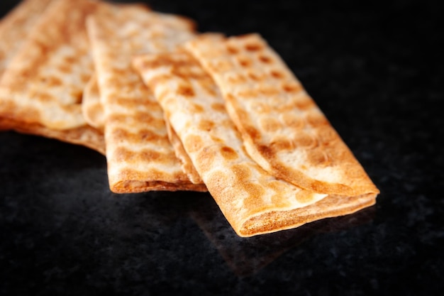 Three fried crispy cookies stacked on a black background Freshly baked cookies