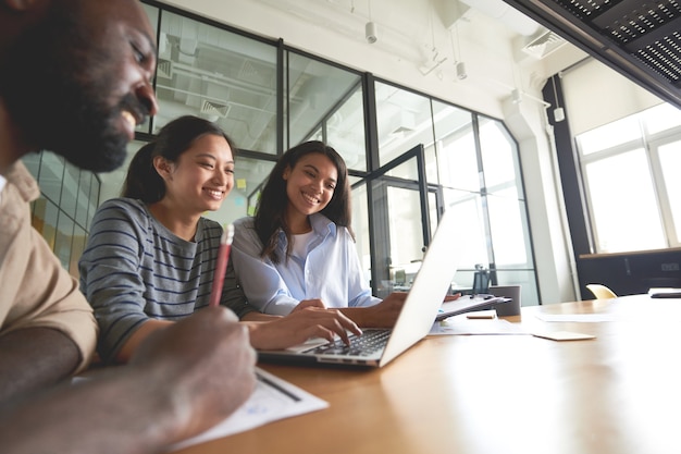 Three friendly coworkers looking at computer screen