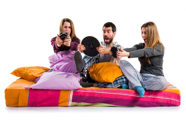 Three friends on a bed holding vintage clock