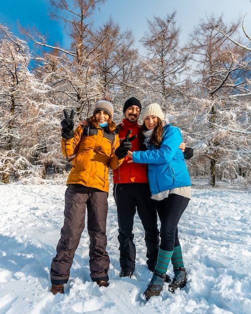 Tre amici che si godono nel bosco innevato nel mese di gennaio il parco naturale artikutza a oiartzun