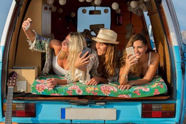 Three friends taking a selfie while lying inside a van