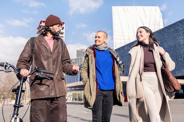 Three friends talking and strolling through the city