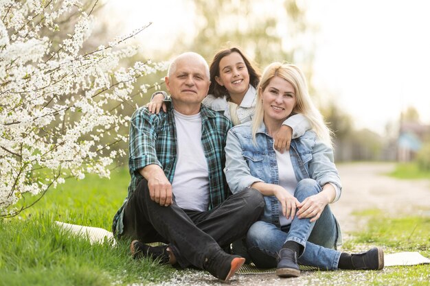 Three generation family sitting outside in spring nature