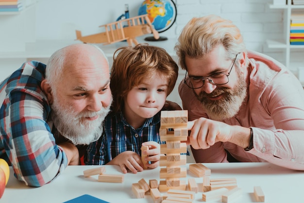 Three generations of active men playing in living room laughing grandparent with son and grandchild