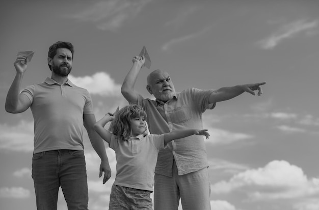 Three generations of men together portrait of smiling son father and grandfather with a toy airplane