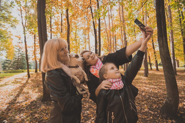 Три поколения женщин и собак с удовольствием смотрят в камеру, вместе позируя для автопортрета