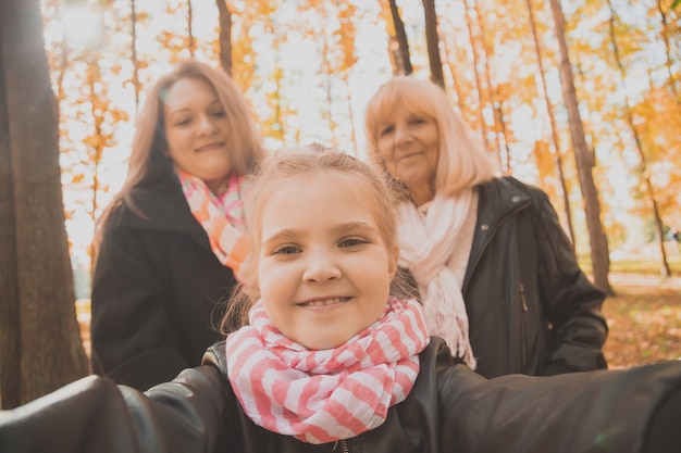 Three generations of women and dog feel fun look at camera posing for selfportrait picture together