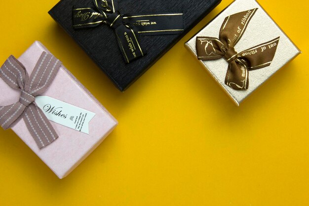 Three gift boxes are isolated on yellow background used in christmas party concepts