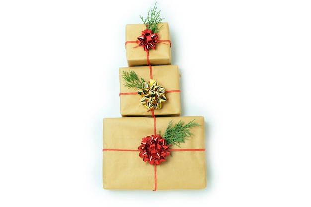 Three gifts boxes in the form of christmas tree of craft paper tied with a red rope and a bow