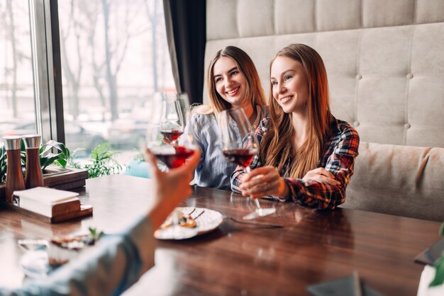 Tre amiche che tengono le bevande in bicchieri