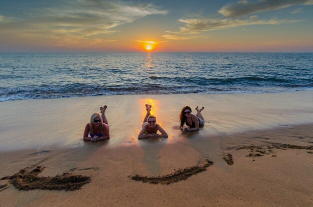 Three girls on the beach at sunset