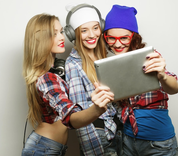 Foto tre amiche che prendono selfie con la tavoletta digitale