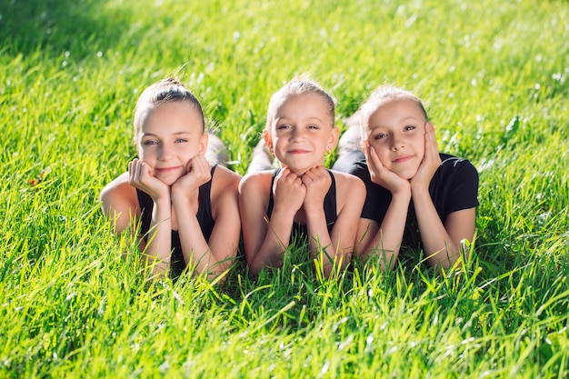 Foto tre ragazze che si trovano nell'erba e divertirsi