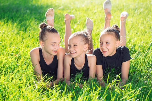 Three girls lying in the grass and having fun