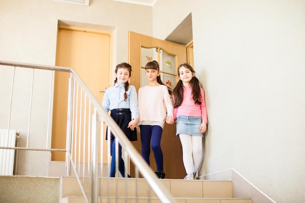 Three girls in the school hallway talking resting during the break