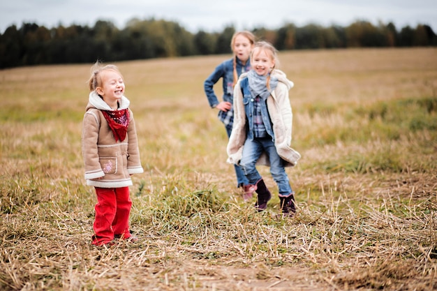 Three girls sisters girlfriends in the field in the cold season