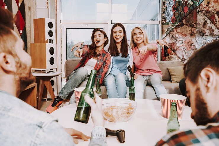 Photo three girls sit on couch and laughing from jokes.
