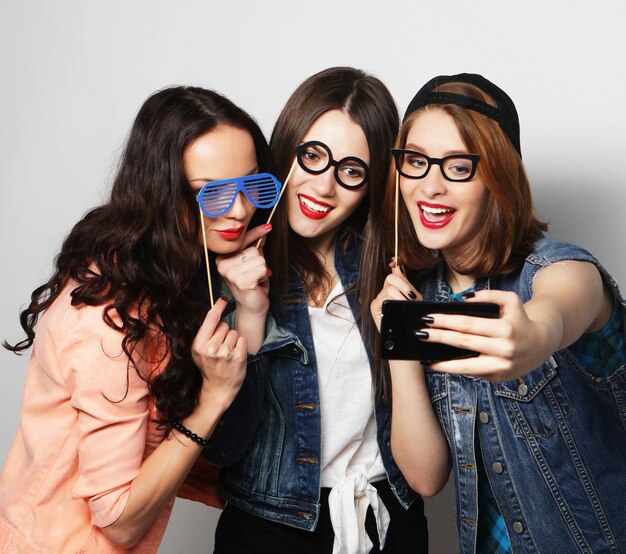 Три девушки делают селфи в поддельных очках