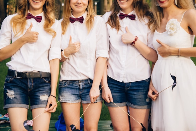 Foto tre ragazze in camicie bianche e shorts in denim. addio al nubilato