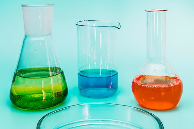 Three glass laboratory flasks with solutions of different\
colors the concept of medical and chemical experiments and research\
laboratory research closeup copyspace