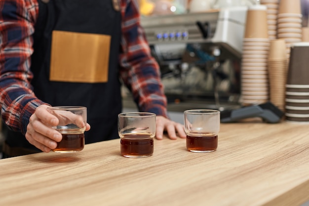 Three glasses of freshly brewed coffee on wooden table