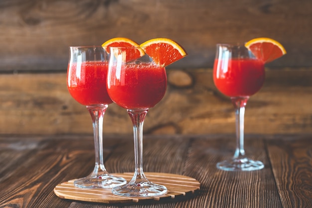 Three glasses of Mimosa cocktail on the wooden table