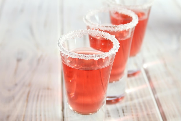 赤いアルコール飲料と3つのグラス背景木製テーブル