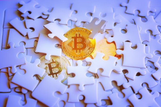 Three Gold bitcoin on white jigsaw or puzzle