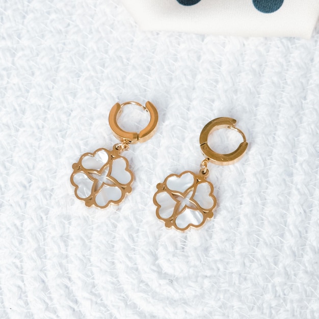 Photo three gold earrings with a heart shaped design on them.