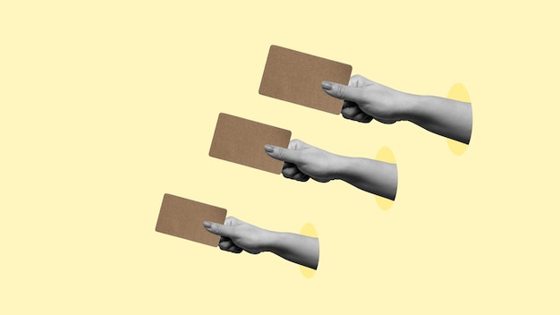 three hands holding cards with a yellow background