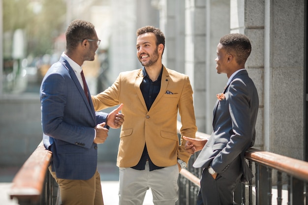 three handsome adult men in suits communicate