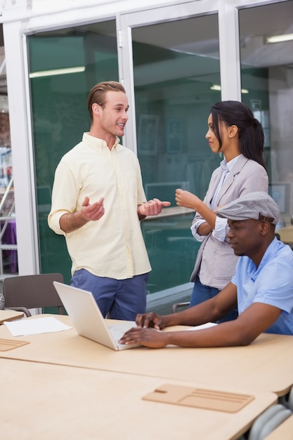 Three happy businessmen working together on a laptop