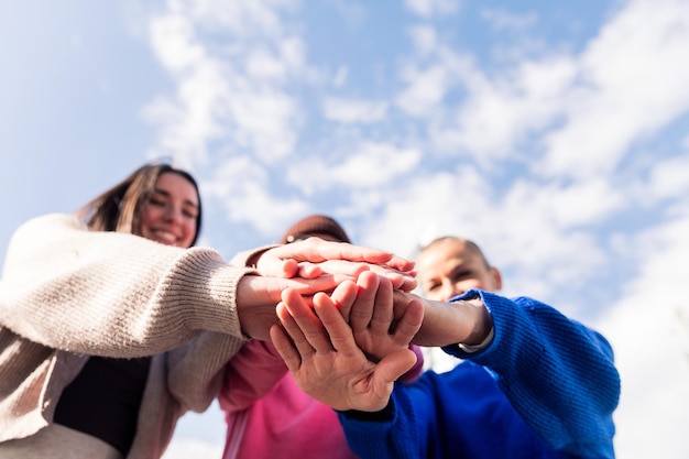 Three happy friends holding hands in unity