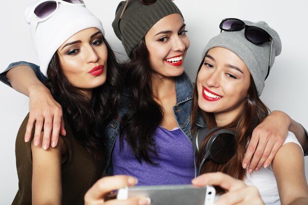 Foto tre ragazze adolescenti felici con lo smartphone prendendo selfie