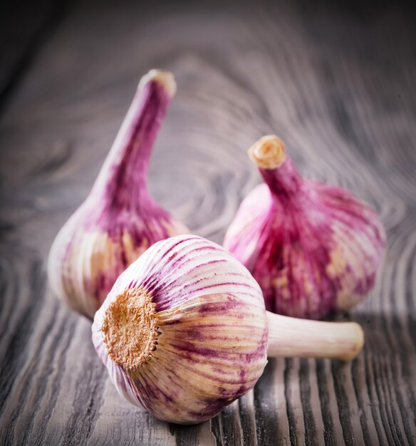 Three heads of garlic on wooden table