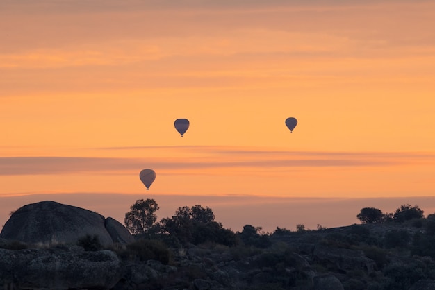 Three hot air balloons near the Natural Area of Los Barruecos. Extremadura. Spain.