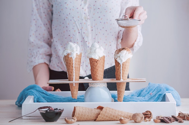 Photo three ice cream cones on a wooden surface