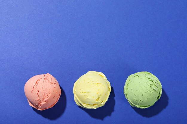 Three ice cream scoops on blue background