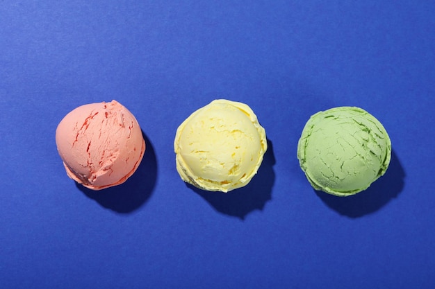 Three ice cream scoops on blue background