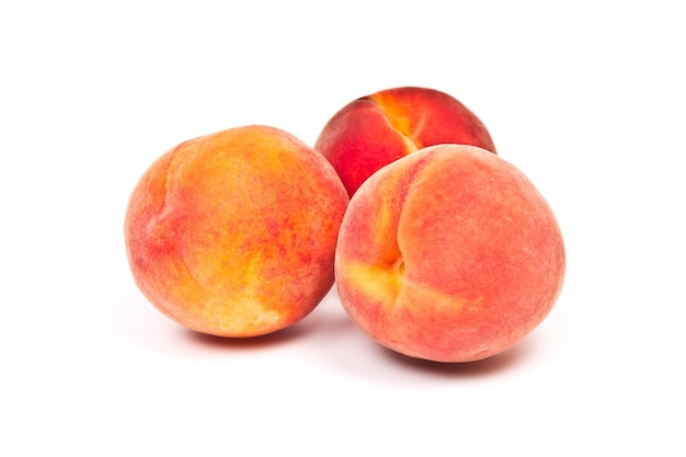 Три сочных сладких персика на белом фоне