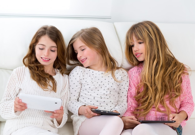 Tre ragazze di amici di sorella di ragazzi giocare insieme con tablet pc