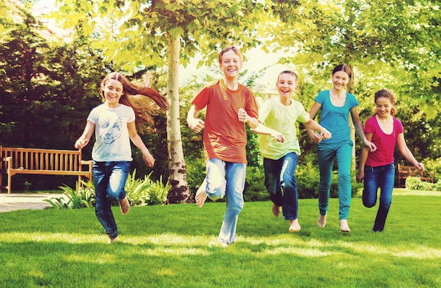 Foto tre bambini che corrono nel parco giochi in una giornata di sole