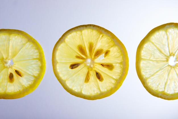 Three lemon slices close up with seeds on white background